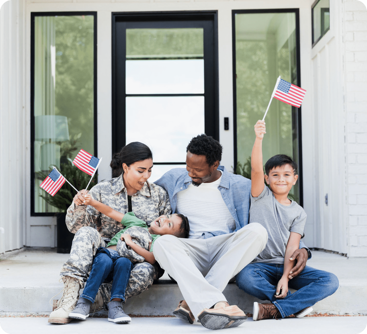 Family sitting with American flags, smiling.